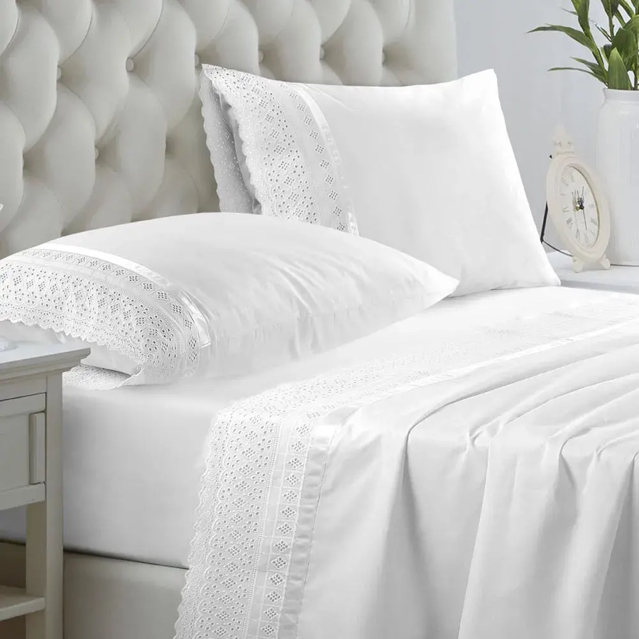Cama con sábanas blancas broderie